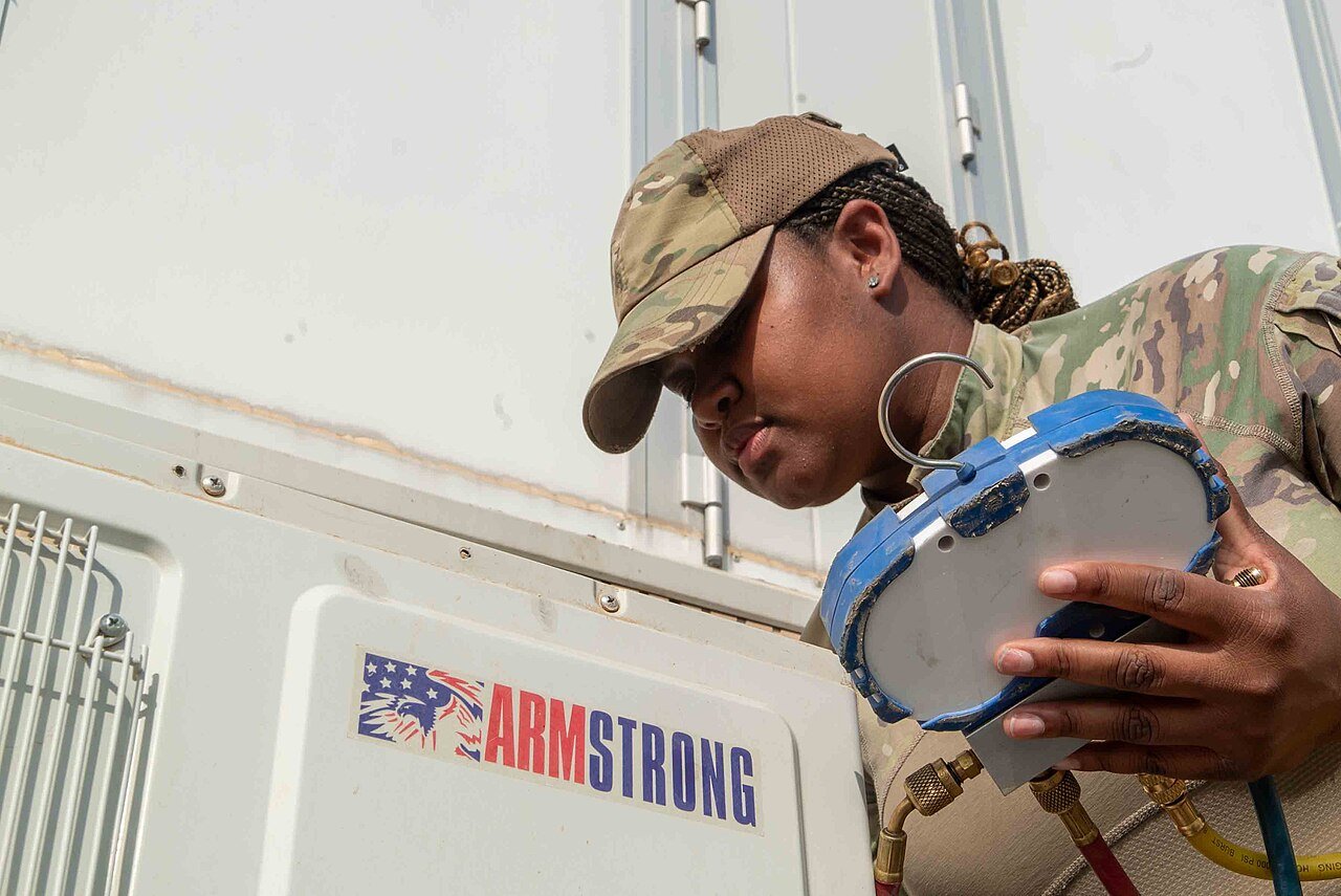 HVAC-R technician reading refrigerant pressures on a service call